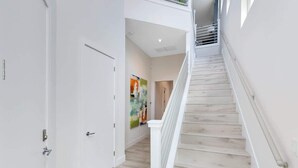 A modern interior with a staircase, white walls, and a wooden floor. - Reunion Resort Villa: Private Pool, Full Amentiy Access (Reunion)