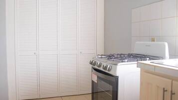 A kitchen with a stove, oven, and white cabinets.