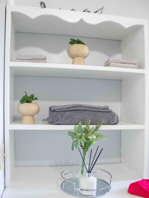 A bathroom with a white vanity, a towel rack, and a glass soap dish with a plant. - Apt 2 Stylish 2 bed Cosy and Comfortable (Potters Village)