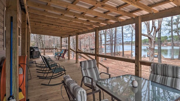 A covered outdoor deck with seating and a grill, overlooking a lake. - 'Bayside' Louisiana Vacation Rental w/ Dock! (Many)