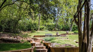 A wooden staircase leading up to a deck surrounded by lush greenery and trees. - Mountain Aire Cottages, Inn & Glamping (Clayton)