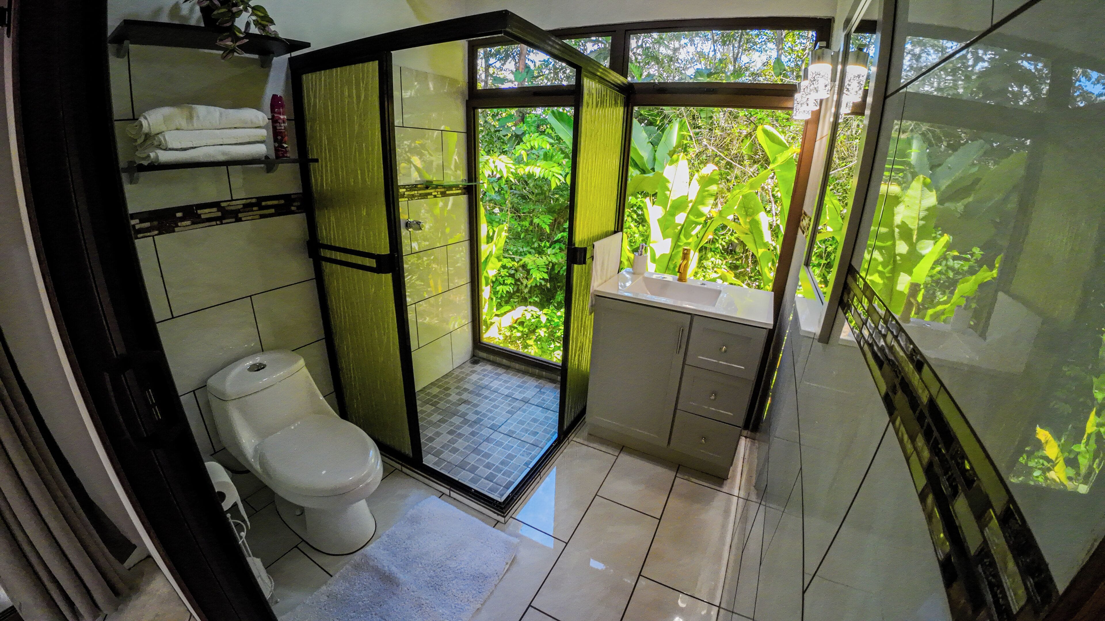Un baño pequeño con inodoro, cabina de ducha y lavabo.