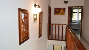 Una escalera con barandillas de madera y un aplique en la pared.