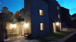 A stone building with a patio, a small table, and a bench. - The Domo farmhouse and its ancient charm (Toscana)