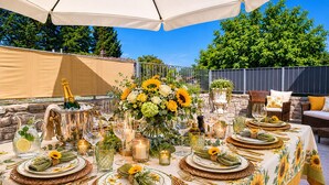 An outdoor dining setup with a table set for a meal, surrounded by greenery and a clear sky. - The Domo farmhouse and its ancient charm (Toscana)