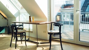 A modern kitchen with a wooden table and chairs, large windows, and a skylight.