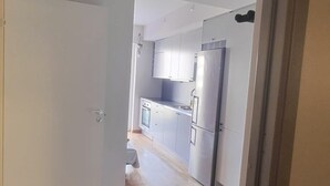 A modern kitchen with stainless steel appliances, wooden flooring, and white cabinetry. - Apartment in Sundbyberg , Stockholm (Sundbyberg)