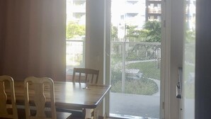A room with a dining table and chairs, a bed with a blanket, and a sliding glass door leading to an outdoor area. - Apartment in Sundbyberg , Stockholm (Sundbyberg)