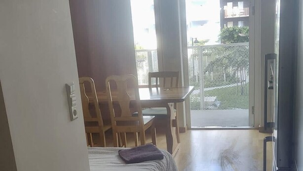 A room with a bed, a desk, and a chair. There is a balcony with a view of buildings. - Apartment in Sundbyberg , Stockholm (Sundbyberg)