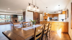 Una cocina amplia con armarios de madera, una isla grande e iluminación colgante.