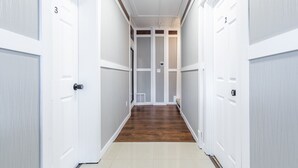 A hallway with white doors numbered 2 and 3, leading to a room with a wooden floor and a window. - 8037-Walk to Mayo- Loft apt in the middle of Mayo campus (Rochester)