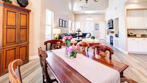 A spacious living area with a dining table set for four, a chandelier, and a large wooden cabinet. - Beautiful Guard Gated Grayhawk Townhome - Available Dates> March 30-April 19! (Scottsdale)