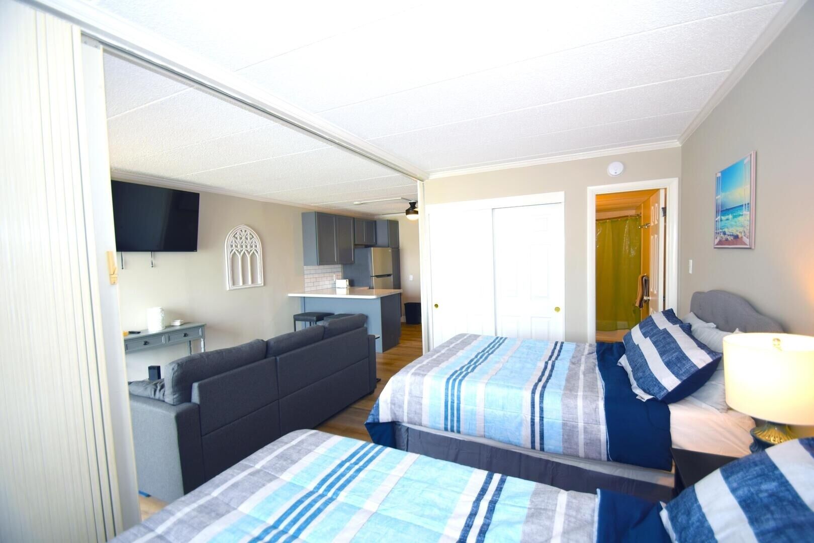 Ein Hotelzimmer mit einem Bett, einer Couch, einem Schreibtisch und einer Küchenzeile.