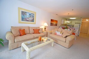 Relax in this stylish living room with two sofas, a coffee table, and a dining area.