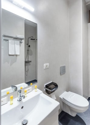 A modern bathroom with a white sink, mirror, and toilet. - Degoya Studios Bucharest Oldtown (Bucharest)