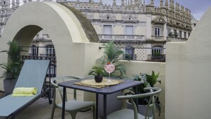 Une terrasse sur le toit, avec une table, des chaises et un fauteuil de relaxation.