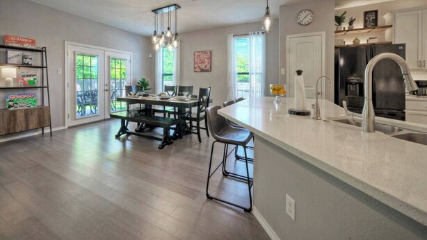 A spacious kitchen with a central island, modern appliances, and a dining area with a view to the outdoors. - 🔆 Sunny Delight of Pville 🔆 (Pflugerville)