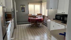 A compact kitchen with a dining table, chairs, a microwave, and a dishwasher.