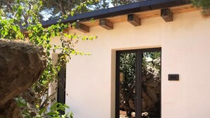 Un edificio moderno con un'ampia porta in vetro, un muro in pietra e una struttura a travi in legno.