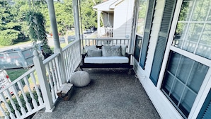 A covered porch with a bench, a doormat, and string lights. - The Nash Spot (Nashville)