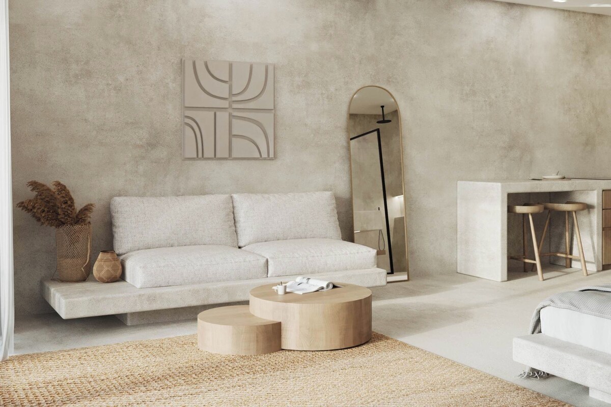 A modern living room with a sofa, a coffee table, a mirror, and a bar area.