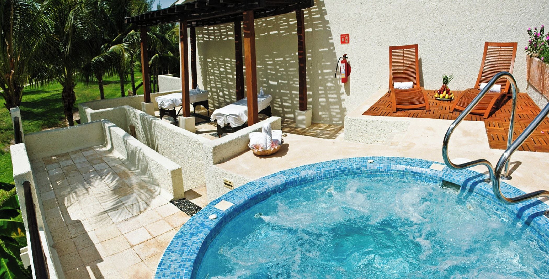 Una piscina con sillas de descanso y un área de estar cubierta.