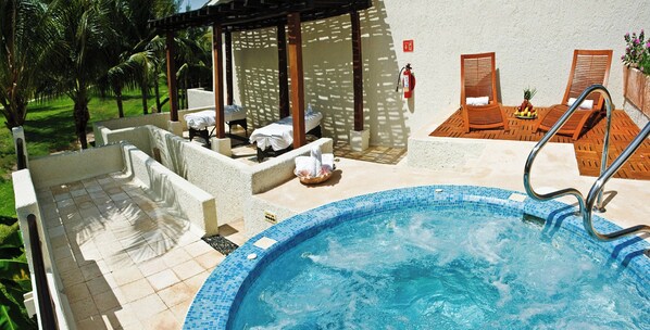 A swimming pool with lounge chairs and a covered seating area.