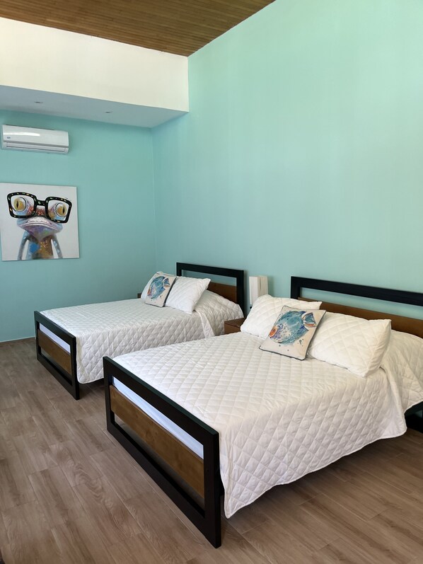 A bedroom with two beds, a wooden ceiling, and a light blue wall. - Modern Beach House-Aslan's Country (Tivives)