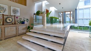 A modern interior with a staircase, framed artwork, and potted plants. - Family Friendly Villa inside Punta Cana Resort&Club with maid included! (Punta Cana)