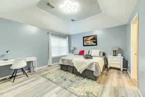 A bedroom with a bed, desk, chair, and a ceiling light fixture. - Comfortable, Upscale House with a pool and spa! (Katy)