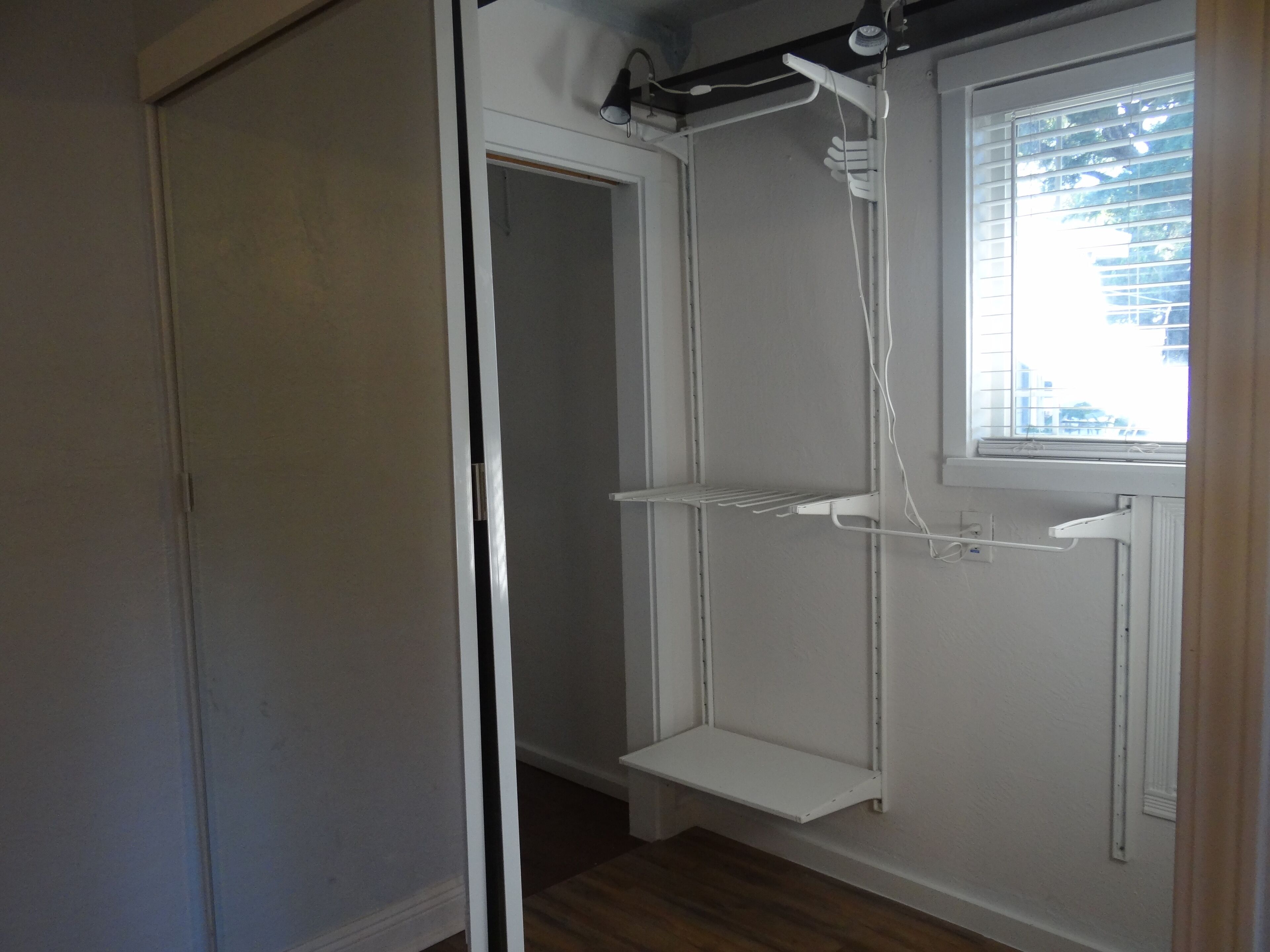 A bathroom with a shower, a window, and a door.