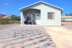 Stylish single-story building with a covered entrance and a paved area featuring interlocking brick patterns.