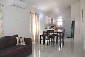 Relax in this stylish living area with a sofa, dining table, and fully equipped kitchen.