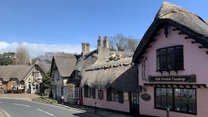 A traditional building with a thatched roof, a sign reading "Old Thatch Teashop," and a road with double yellow lines. - Stylish 1 Bed Apartment with Sea views (Shanklin)