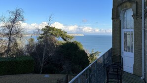 A building with a balcony overlooking a body of water and a clear sky. - Stylish 1 Bed Apartment with Sea views (Shanklin)