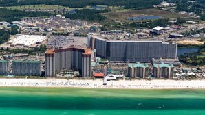 A coastal hotel with multiple high-rise buildings, a beachfront, and a large parking area.