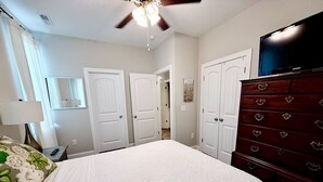 A bedroom with a bed, dresser, and ceiling fan. - Budget Friendly Bungalow (Raleigh)