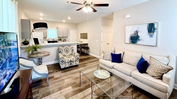 A modern living room with a sofa, coffee table, and a television. - Budget Friendly Bungalow (Raleigh)