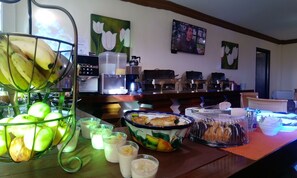 Ein reichhaltiges Frühstücksbuffet mit Früchten, Getränken und Gebäck.