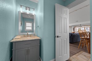 A bathroom with a sink, mirror, and vanity. - 8BR Oceanfront home - Game & theater rooms, private pool, hot tub ★★★★★ (Waves)