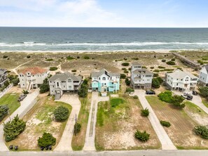 A coastal residential area with multiple houses, a beach, and a pier. - 8BR Oceanfront home - Game & theater rooms, private pool, hot tub ★★★★★ (Waves)