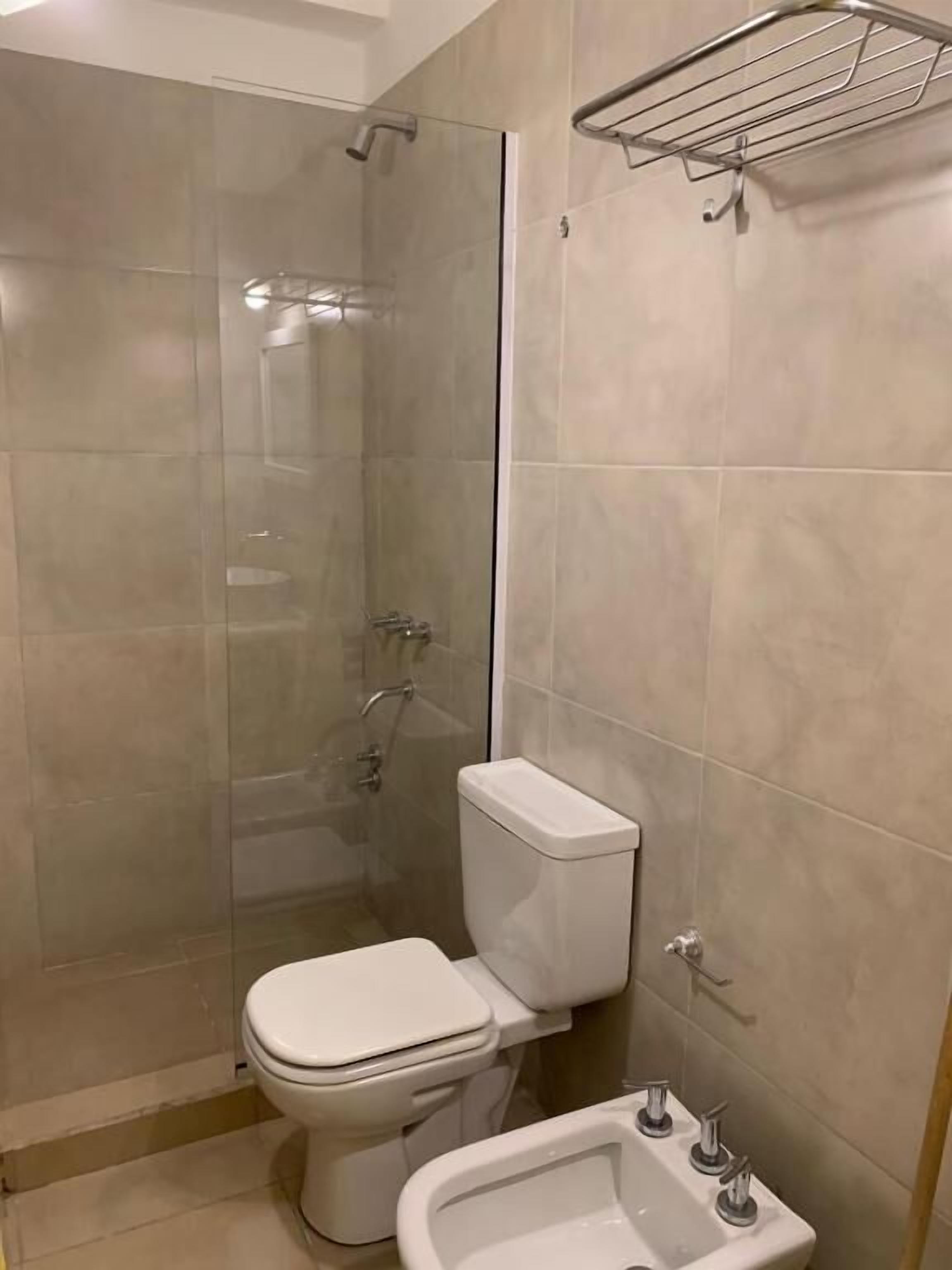 A bathroom with a toilet, bidet, and sink.