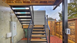 A modern staircase with metal railings and wooden steps, leading to a covered area with a view of the sky. - Grand Junction Home ~ 1 Mi to Downtown (Grand Junction)