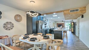 Une cuisine moderne dotée d’un îlot central, d’appareils électroménagers en acier inoxydable et d’un coin repas avec une table ronde et des chaises.