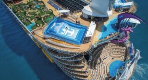 A cruise ship with a large swimming pool, a theater, and a water slide.