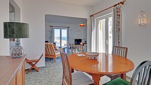A dining area with a round wooden table, chairs, a vase, and a lamp.