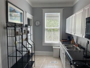 Compact kitchen with a stove, sink, and cabinetry, offering ample space for meal preparation.