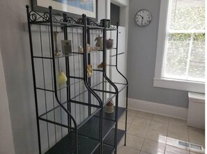 Comfortable room with a shelving unit, tiled floor, and window with blinds.