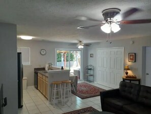 Relax in this inviting living area with a sofa facing the kitchen, complete with a central island and stools.