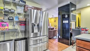 A modern kitchen with stainless steel appliances, a built-in water dispenser, and a wooden dining area. - 5 Mi to National Mall: Home in Washington DC (Washington)